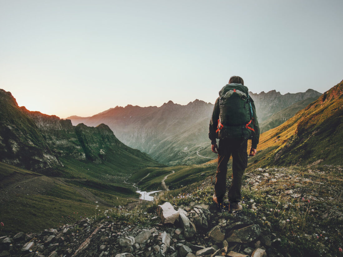 Man,Hiking,At,Sunset,Mountains,With,Heavy,Backpack,Travel,Lifestyle